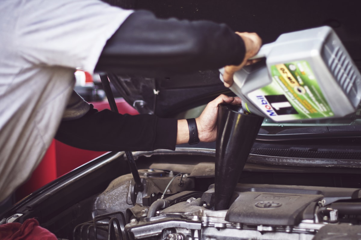 Meccanico al lavoro sul motore di un'automobile in officina